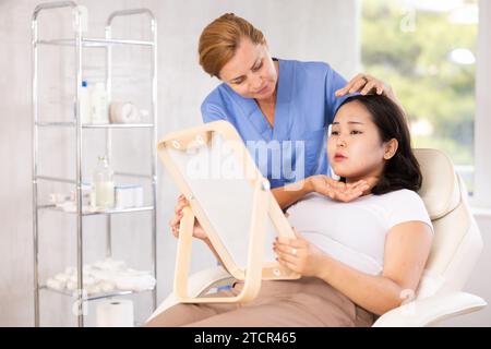 Eine Frau mittleren Alters, die mit dem Spiegel spricht Stockfoto