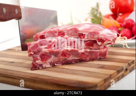 Hacken von frischen Schweineribs mit Gemüse und Kräutern, die fertig zum Kochen sind Stockfoto