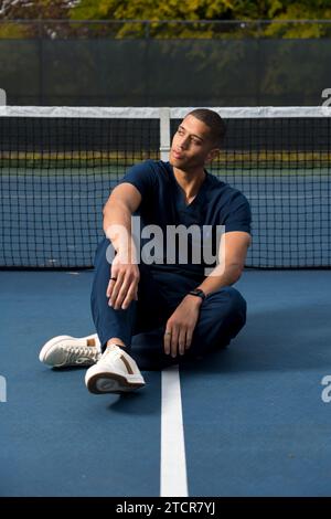 Afroamerikaner Arzt trägt Scrubs Tennis Court am Nachmittag Stockfoto