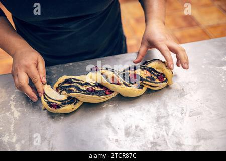 Der Prozess der Babka-Herstellung. Süßes Brot gefüllt mit Mohnsamen, bereit zum Backen Stockfoto