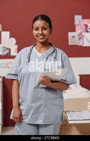 Junge erfolgreiche afroamerikanische Chirurgin oder Assistentin in Uniform, die vor der Kamera auf der Station plastischer Chirurgie steht Stockfoto