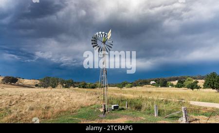 Eine dunkle Sturmfront über einer Windmühle auf Ackerland in Guildford in Central Victoria, Australien. Stockfoto