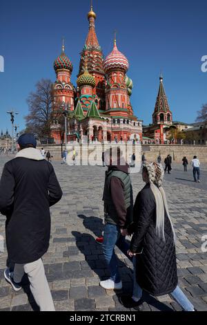 Touristen laufen vor der Kathedrale von Vasily dem Seligen aus dem 16. Jahrhundert, auch bekannt als Basilius-Kathedrale. Roter Platz, Moskau, Russische Föderation. Stockfoto