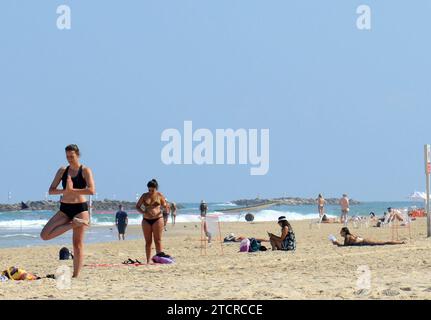 Eine Frau, die Yoga am Strand in Tel Aviv praktiziert. Stockfoto