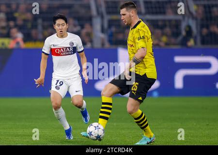 DORTMUND, DEUTSCHLAND - 13. DEZEMBER: Kang-in Lee (Paris Saint-Germain) und Niklas Suele (Borussia Dortmund) während der UEFA Champions League 2023/2024 - G Stockfoto