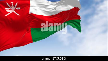 Nationalflagge von Oman winkt an einem klaren Tag im Wind. Vertikaler roter Streifen mit Oman-Emblem und drei horizontalen Streifen: Weiß, rot und grün. 3D Stockfoto