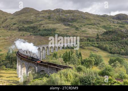 Dampfzug und Glenfinnan-Viadukt in den schottischen Highlands. Berühmte Eisenbahnbrücke, die in TV und Film verwendet wurde, darunter harry Potter als Hogwarts Express. Stockfoto