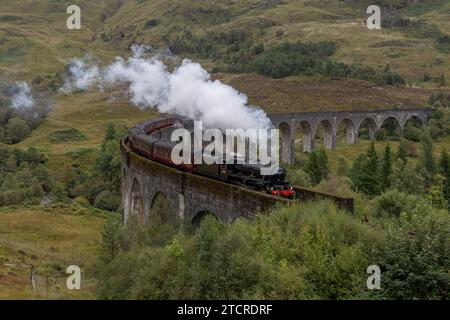 Dampfzug und Glenfinnan-Viadukt in den schottischen Highlands. Berühmte Eisenbahnbrücke, die in TV und Film verwendet wurde, darunter harry Potter als Hogwarts Express. Stockfoto