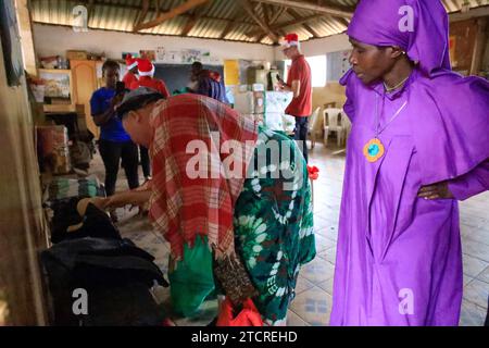 NAIROBI, Afrika. Dezember 2023. Frauen, die Weihnachtskleidung überprüfen, verteilt von Family Care Mission in der orthodoxen katholischen Kirche in Nairobi, Kenia. Die Einwohner von Kibera Slum erhielten Weihnachtsgeschenke von Family Care Missions (einer seit 2001 registrierten Wohltätigkeitsorganisation in Kenia, die sich aus voll- und Teilzeit-Freiwilligen zusammensetzt, die ihre Zeit und ihre Anstrengungen für die Unterstützung von Unterprivilegierten und Benachteiligten der Gesellschaft widmen. Ihre Freiwilligen suchen lohnende Projekte aus, um das Bewusstsein für die „Ärmsten der Armen“ zu schärfen und sie zu unterstützen. FCM bietet Dienstleistungen wie die Beschaffung von Mitteln für Schulessen, Stockfoto