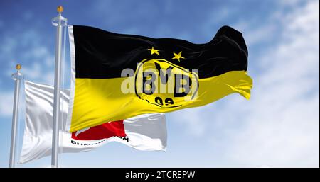 Dortmund, DE, 10. November 2023: Borussia Dortmunder Flagge winkt mit Bundesliga-Flagge an einem klaren Tag. Professioneller deutscher Fußballverein. Illustrative editori Stockfoto