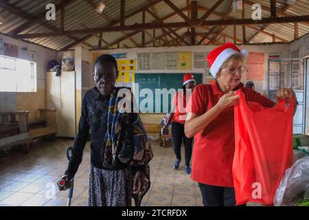 NAIROBI, Afrika. Dezember 2023. Freiwillige bei Family Care Mission verteilen Weihnachtsmahlpakete an Bewohner in Kibera Slum, Nairobi. Die Einwohner von Kibera Slum erhielten Weihnachtsgeschenke von Family Care Missions (einer seit 2001 registrierten Wohltätigkeitsorganisation in Kenia, die sich aus voll- und Teilzeit-Freiwilligen zusammensetzt, die ihre Zeit und ihre Anstrengungen für die Unterstützung von Unterprivilegierten und Benachteiligten der Gesellschaft widmen. Ihre Freiwilligen suchen lohnende Projekte aus, um das Bewusstsein für die „Ärmsten der Armen“ zu schärfen und sie zu unterstützen. FCM bietet Dienstleistungen wie die Beschaffung von Mitteln für Schulessen, Schulgebühren, Stockfoto