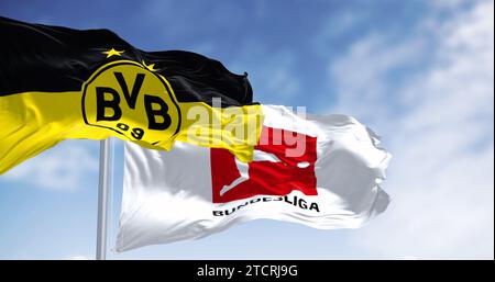 Dortmund, DE, 10. November 2023: Borussia Dortmunder Flagge winkt mit Bundesliga-Flagge an einem klaren Tag. Professioneller deutscher Fußballverein. Illustrative editori Stockfoto