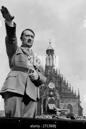Auf dem Reichsparteitag 1934 wird Adolf Hitler den Nazi-Gruß, ein Symbol der Treue innerhalb des Regimes, geben. Diese Kundgebung war besonders bedeutsam, als sie der Nacht der Langen Messer folgte und Hitlers Macht durch die Beseitigung der Opposition innerhalb der Partei festigte. Das Bild fängt die erhöhte Atmosphäre der Loyalität und Einheit ein, die das Regime im Gefolge dieses entscheidenden Ereignisses zu projizieren versuchte. Stockfoto