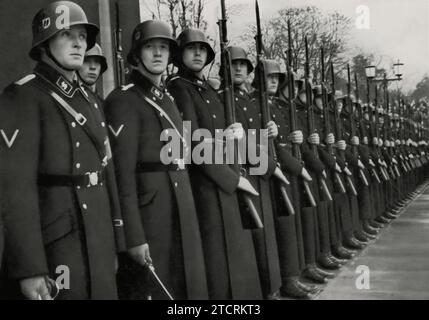 Am 9. November 1935 ist auf dem Königsplatz in München die Leibstandarte des Führers in prominenter Form zu sehen. Dieses Datum anlässlich des Jubiläums der Bierhalle Putsch ist ein bedeutender Gedenktag für die NSDAP. Die Anwesenheit der Leibstandarte an diesem Ort unterstreicht die Bedeutung der Loyalität und der Erinnerung an die frühen Kämpfe der Partei, wobei der Königsplatz als symbolische Kulisse für diesen feierlichen Anlass dient. Stockfoto