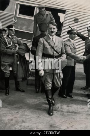 Ein Foto von Adolf Hitler, der vor der Seitentür eines deutschen Flugzeugs steht, mit dem Satz „der Führer fordert durch sein Beispiel die Luftfahrt“, übersetzt mit „der Führer fördert die Luftfahrt durch Beispiel“. Dieses Bild dient als Propaganda und unterstreicht Hitlers Einfluss bei der Stärkung der Luftwaffe als Symbol für nationale Stärke und technologischen Fortschritt in den 1930er Jahren Stockfoto