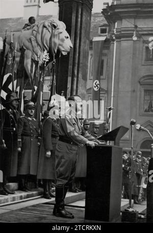 Im November 1934 wird Adolf Hitler in München gefangen genommen und spricht vor der Feldherrnhalle vor den neuen Mitgliedern der Hitlerjugend und des Deutschen Mädchenbundes. Dieses Ereignis war ein bedeutender Moment, als Hitler sich an die jüngere Generation wandte, die in diese Nazi-Organisationen aufgenommen wurde. Die Feldherrnhalle, ein symbolischer Ort in München, bildete eine historisch resonante Kulisse für diesen Anlass. Stockfoto