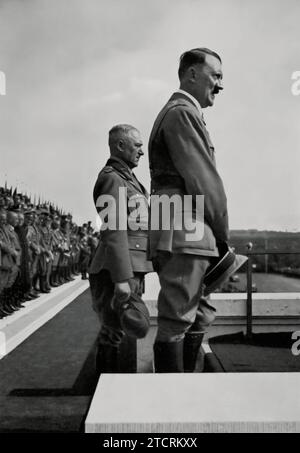 Adolf Hitler wird zusammen mit dem Reichsarbeitsführer Konstantin Hierl vor 47.000 Arbeitern beim Reichsparteitag 1935 gezeigt. Diese Versammlung war eine bedeutende Demonstration der organisierten Arbeit unter dem Nazi-Regime, wobei die massive Versammlung von Arbeitern Einheit und Stärke symbolisierte. Die Anwesenheit von Hitler und Hierl bei dieser Veranstaltung unterstreicht die Betonung des Regimes auf die Arbeit als Schlüsselkomponente seiner Sozial- und Wirtschaftspolitik. Stockfoto