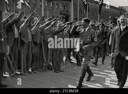 Am 5. Mai 1934 nimmt Adolf Hitler an der Grundsteinlegung für das neue Reichsbankgebäude Teil, ein bedeutendes Ereignis in der wirtschaftlichen Entwicklung des NS-Deutschlands. Diese Zeremonie symbolisiert den Fokus des Regimes auf Finanzkontrolle und architektonische Pracht und spiegelt seine umfassenderen Ambitionen wider, Deutschlands Wirtschaftslandschaft neu zu gestalten. Stockfoto