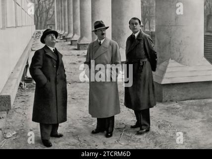 Adolf Hitler untersucht zusammen mit Professor Gall und dem Architekten Albert Speer den Baufortschritt des Hauses der Deutschen Kunst in München. Dieser Besuch beleuchtet die Zusammenarbeit zwischen Hitler und prominenten Architekten bei der Verwirklichung seiner Vision für die Nazi-Architektur. Das Haus der Deutschen Kunst, ein Schlüsselprojekt des Regimes, sollte die Nazi-ideale in Kunst und Architektur verkörpern. Speer, bekannt für seine enge Verbindung zu Hitler, spielte eine entscheidende Rolle bei der Verwirklichung dieser architektonischen Visionen, wobei das Haus der Deutschen Kunst ein Paradebeispiel für ihre gemeinsamen Bemühungen war. Stockfoto