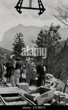 Adolf Hitlers Interesse am Straßenbau zeigt sich bei seinem Besuch auf der Alpenstraße, was seine direkte Beteiligung an der Infrastrukturentwicklung in Deutschland unterstreicht. Dieser Besuch unterstreicht die Bedeutung, die er dem Bau eines modernen und ausgedehnten Straßennetzes beimisst, wobei die Alpenstraße ein hervorragendes Beispiel für diese Bemühungen ist. Der Bau solcher Straßen war nicht nur ein Beweis für Ingenieurskunst, sondern auch im Einklang mit Hitlers Vision, das Land durch strategische Infrastrukturprojekte zu verbinden und zu verbessern. Stockfoto