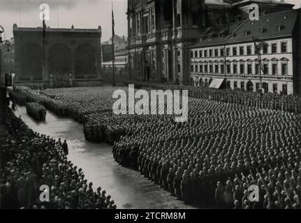 Am 7. November 1935 symbolisiert die erste Vereidigung der Volksheer in der Feldherrnhalle in München, einem Ort der gescheiterten Bierhalle Putsch von 1923, den Aufstieg des NS-Regimes aus vergangenen Misserfolgen. Tausende von Soldaten und Unterstützern versammelten sich hier und machten einen Ort früherer Niederlage in eine starke Demonstration der militärischen Stärke und Loyalität des Regimes. Stockfoto