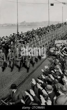 Das Bild zeigt den Einzug deutscher Truppen über die Mainzer Rheinbrücke am 7. März 1936 und symbolisiert einen kritischen Moment im Vorfeld des Zweiten Weltkriegs Die Remilitarisierung des Rheinlandes, vertreten durch diesen marsch, stellte einen direkten Verstoß gegen den Vertrag von Versailles dar und war eine kühne Behauptung, dass Nazi-Deutschland die internationale Ordnung nach dem Ersten Weltkrieg missachtet. Diese Veranstaltung zeigte nicht nur deutsche militärische Stärke, sondern veränderte auch die geopolitische Landschaft Europas zu dieser Zeit erheblich. Stockfoto