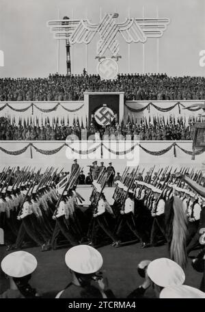 Während der Nürnberger Rallye 1935, am Tag der Bundeswehr, werden Mitglieder der Kriegsmarine in einer marschvergangenheit gesehen. Diese Veranstaltung hebt die Rolle der Marinestelle im militärischen Schaukasten des Nazi-Regimes hervor. Die disziplinierte Prozession der Kriegsmarine vor dem Hintergrund eines bedeutenden politischen und militärischen Treffens unterstreicht die Bedeutung der Marinestreitkräfte im weiteren Kontext der damaligen deutschen Streitkräfte. Stockfoto