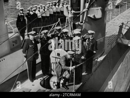 Im August 1935 inspiziert Adolf Hitler die ersten deutschen U-Boote in Kiel, was eine bedeutende Entwicklung der Fähigkeiten der Kriegsmarine darstellt. Diese Veranstaltung beleuchtet die strategische Expansion der deutschen Marine, wobei die Einführung von U-Booten eine entscheidende Rolle in der militärischen Strategie des Regimes spielt. Die Inspektion in Kiel, einem wichtigen Marinestützpunkt, unterstreicht die Bedeutung, die fortschrittlichen maritimen Technologien und Kriegstechniken in Nazi-Deutschland beigemessen wird. Stockfoto