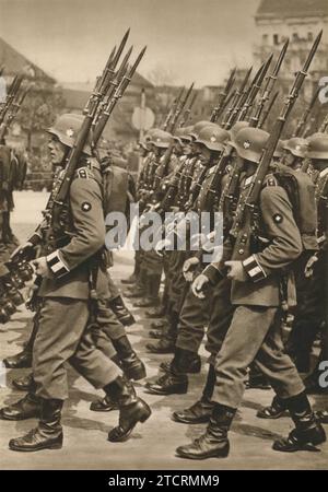 Soldaten der Wehrmacht, der deutschen Armee, marschierend, um 1935. In voller Militäruniform gekleidet, veranschaulichen diese Truppen die disziplinierte Formation und Ordnung, die die Marschübungen der Wehrmacht kennzeichneten. Stockfoto