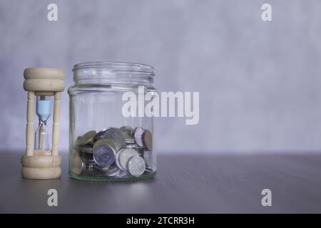 Nahaufnahme von Sanduhr und Münzen mit Kopierraum für Text. Finanzkonzept. Stockfoto