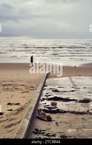 Einsamer Spaziergänger am Strand von St. Annes im Winter Stockfoto