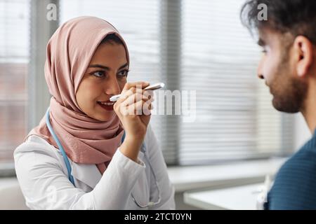 Muslimische Ärztin, Die Das Sehvermögen Der Patienten Überprüft Stockfoto
