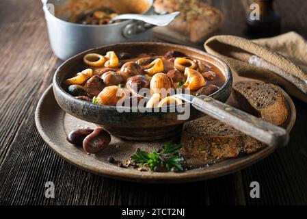 Frischer Bohneneintopf mit Nudeln auf hölzernem Hintergrund aus nächster Nähe Stockfoto