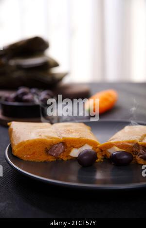 Typisches Gericht von Peru unter dem Namen Tamales bekannt, mit Maismehl, Huhn oder Schweinefleisch, Knoblauch, Chili, schwarzen Oliven und Ei gemacht. Stockfoto