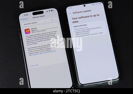 New York, USA - 11. Dezember 2023: Aktualisierung des Systems auf dem Bildschirm des iPhone und Android-Smartphones in Nahansicht Stockfoto