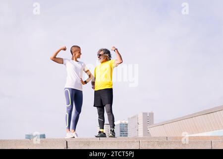 Mann und Trainer feiern Erfolg und zeigen Muskeln Stockfoto