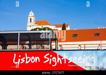 Open Top Sightseeing Bus vor dem Kreuzfahrtschiff Dock. Lissabon, Portugal. Die St. Michael Kirche ist dahinter. Bezirk Alfama. Stockfoto