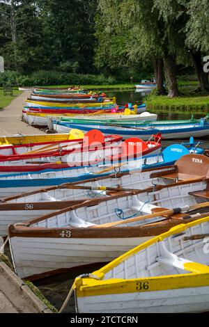 Farbenfrohe Ruderboote auf der Meare in Thorpeness, Suffolk, England, Großbritannien Stockfoto