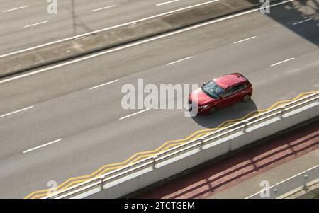 Rotes Auto fährt auf der Autobahn, mit verschwommener Anzeige Bewegung in der Umgebung. Stockfoto