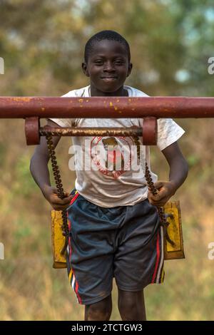 Schulkind, das im Schulhof schwingt, Ziwa, Uganda Stockfoto