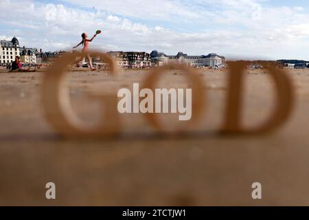 Hölzerne Buchstaben, die das Wort GOTT auf einem Hintergrund aus Strandsand bilden. Christliches Symbol. Stockfoto