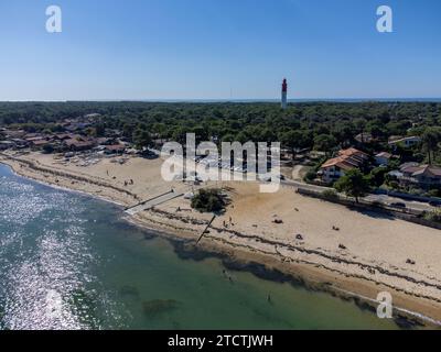 Blick aus der Vogelperspektive auf die Bucht von Arcachon mit vielen Fischerbooten und Austernfarmen, Wald und rotem Leuchtturm Le Phare du Cap Ferret, Halbinsel Cap Ferret, Fra Stockfoto