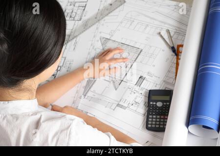 Ingenieurin entwirft architektonische Pläne am Schreibtisch Stockfoto