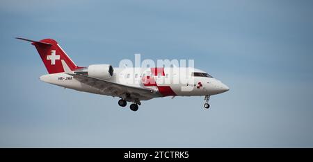 Teneriffa, Spanien, 10. Dezember 2023. Bombardier Challenger 650 Swiss Air-Ambulance fliegt im blauen Himmel. Landet am Flughafen Teneriffa Stockfoto