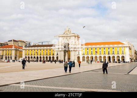 Touristen in der Praca do Comercio mit dem Arco da Rua Augusta-Bogen. Lissabon, Portugal Stockfoto