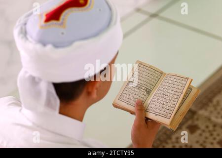 Jamiul Azhar Moschee. Muslimischer Mann, der einen arabischen Koran liest. Vietnam. Stockfoto