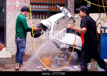 Mitarbeiter waschen einen Roller. Stockfoto