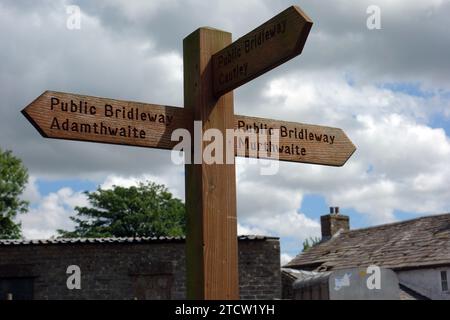 Hölzerner Wegweiser für öffentliche Bridleway nach Adamthwaite & Murthwaite vom Landwirtschaftsdorf Narthwaite im Howgills, Yorkshire Dales National Park. Stockfoto