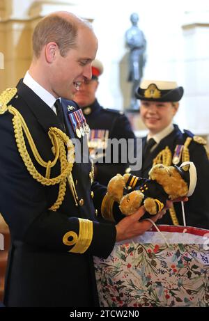 Der Prinz von Wales erhält ein Geschenk an die Lord High Admiral's Divisions am Britannia Royal Naval College in Dartmouth, wo er eine Parade von 202 Kadetten der Royal Navy sah, die zusammen mit internationalen Offizierskadetten aus Oman, Kuwait, Bangladesch und Trinidad und Tobago ausfielen. Bilddatum: Donnerstag, 14. Dezember 2023. Stockfoto