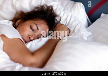 Frau, die im Bett mit Kissen schläft. Stockfoto